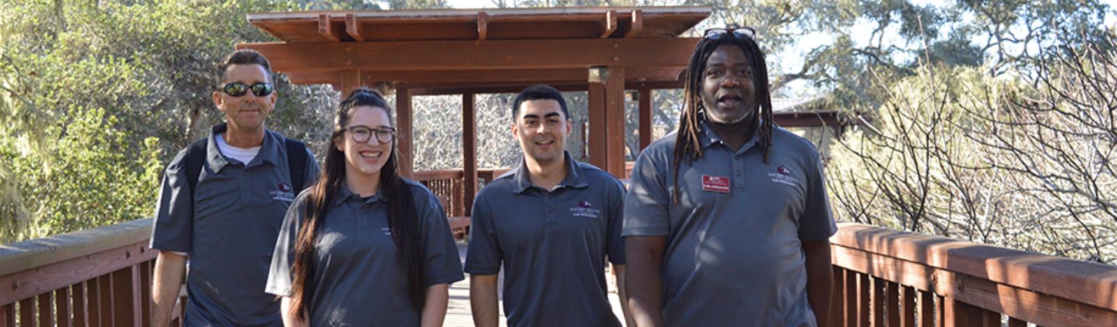 Image of four Lobos Ambassadors Walking Across a bridge on the Monterey MPC campus