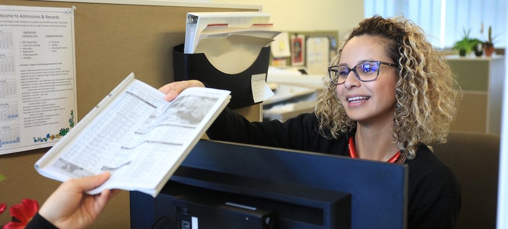 Woman handing over workbook