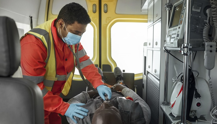 Female paramedic assists patient in ambulance