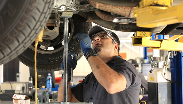 MPC Auto Tech student makes sure everything is tight and secure under the car