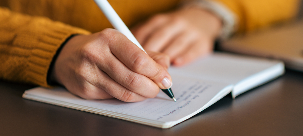 person writing in journal