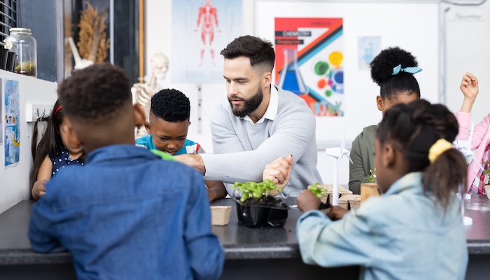 Elementary School Teacher Working with Students in Classroom