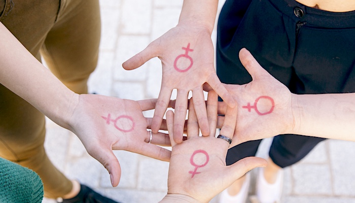 Women in Group Showing Women's Gender Signs Written on Palms