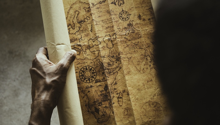 Person Unraveling Old Map