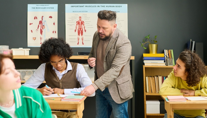 Physiology Students in Class Being Assisted by Teacher