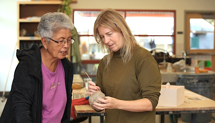 Handbuilding Instructor Assisting Student in Clay Project in Class