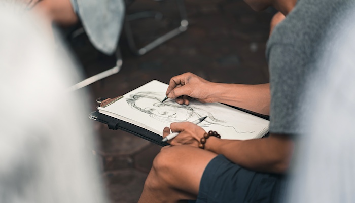 Person Drawing Image of Woman with Pencil