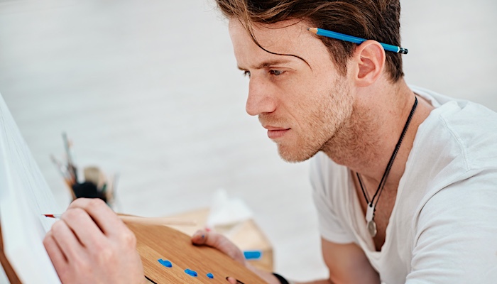 Man Painting on Easel in Studio