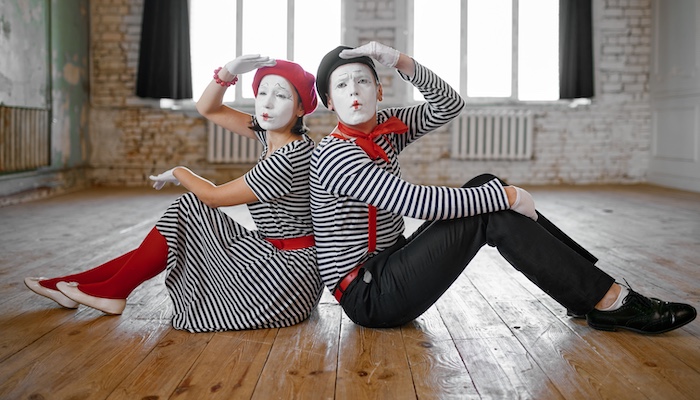 Two Mimes Sitting on a Wooden Floor