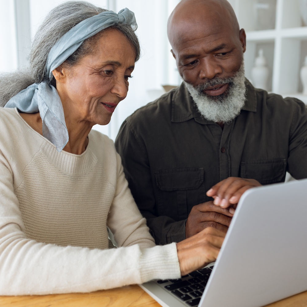 two seniors using laptop together