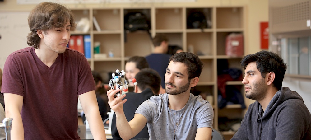 Students in science class looking at model