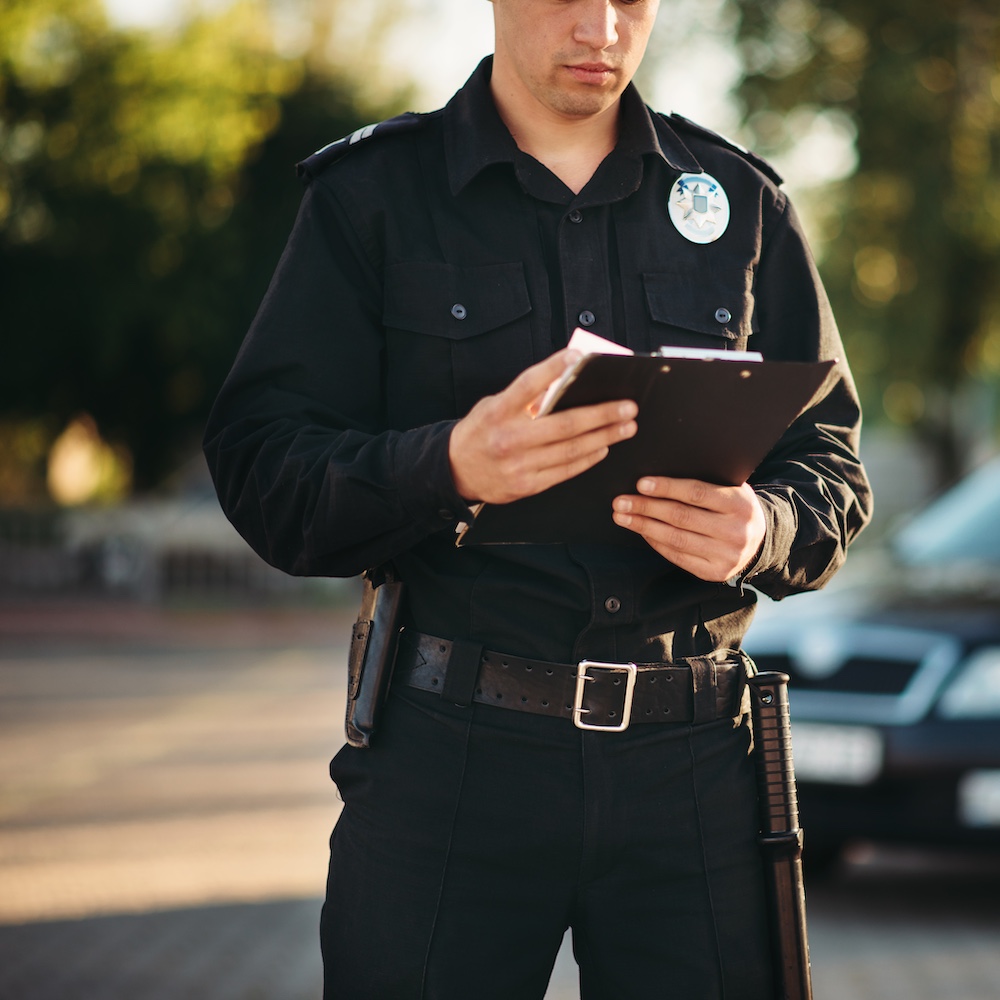 Law Enforcement Officer Looking at Clipboard