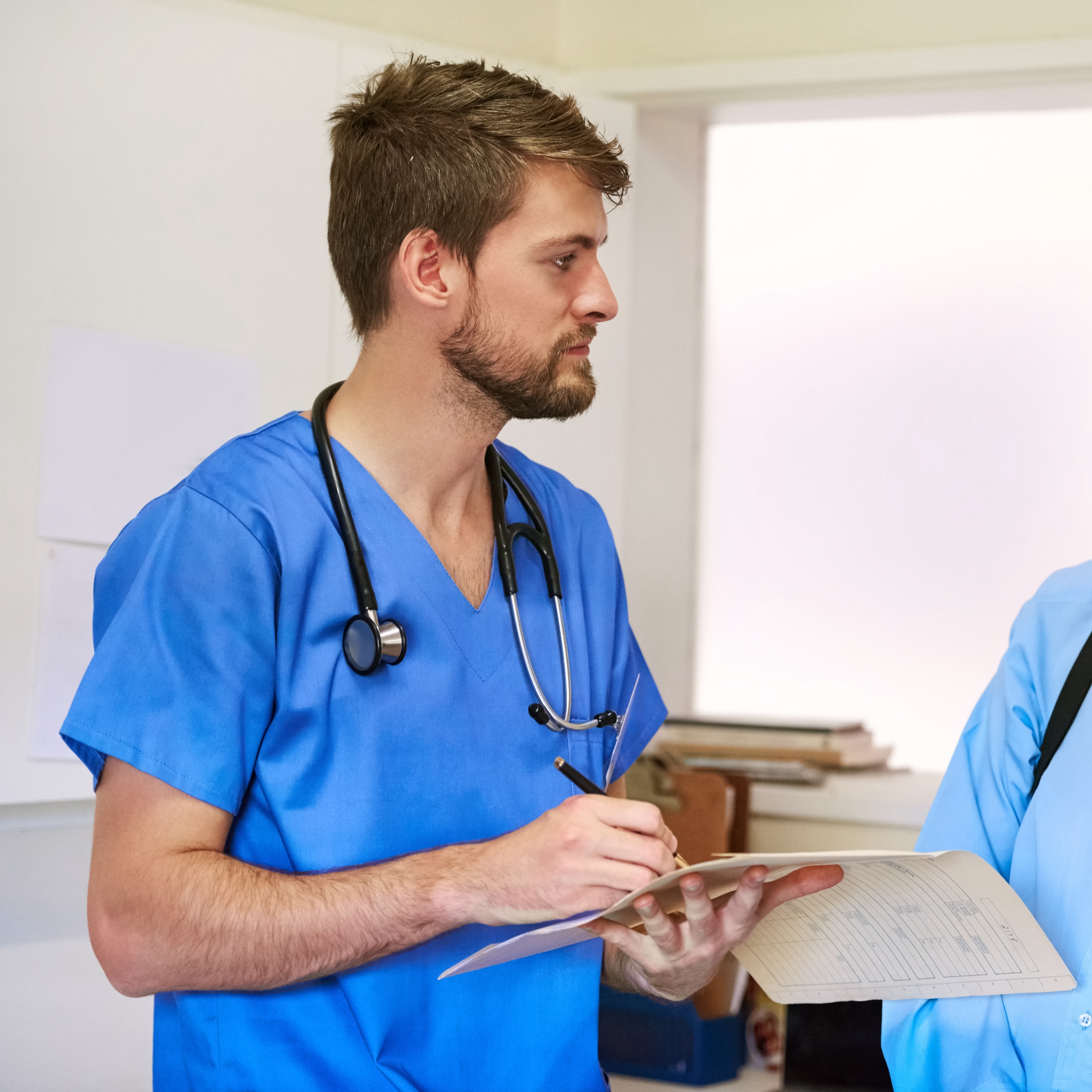 Nurse Holding Clipboard Speaking with Patient