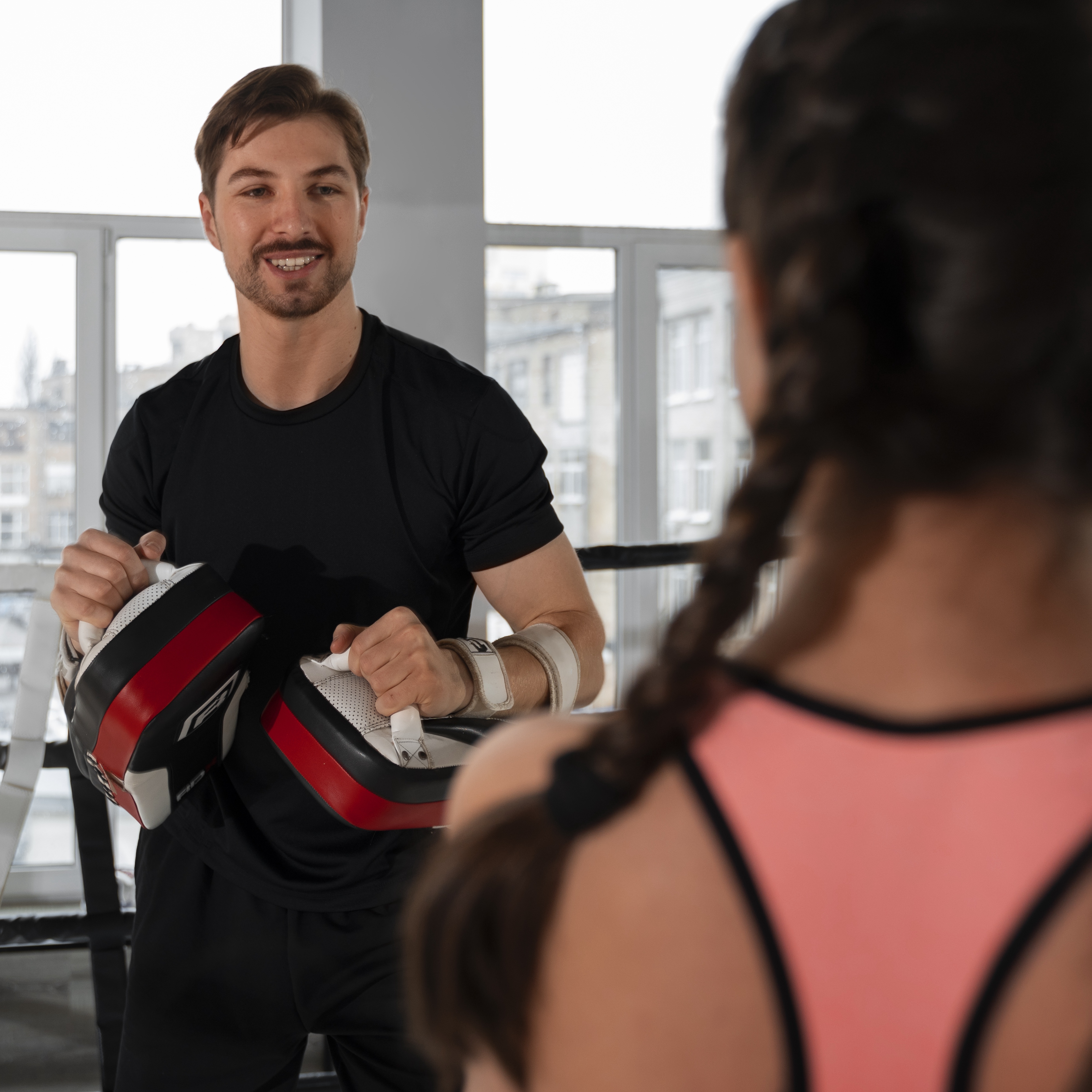 Personal Trainer Holding Boxing Pads with Boxer