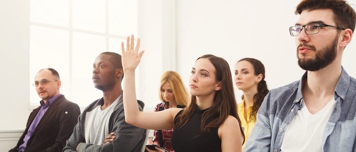 People in Discussion with Someone Raising Hand