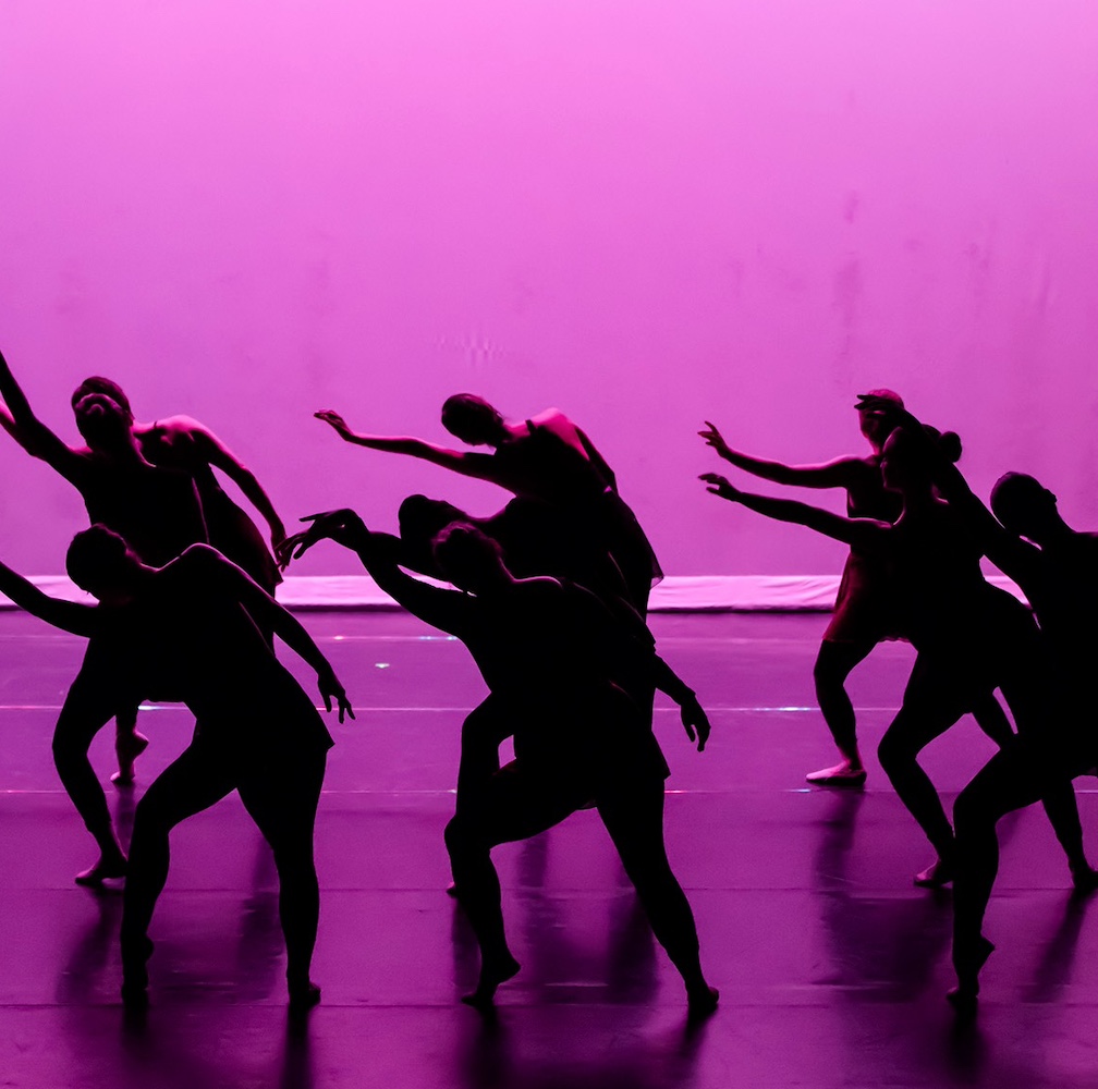 Silhouettes of Students Dancing at MPC Dance Performance in front of Purple Background