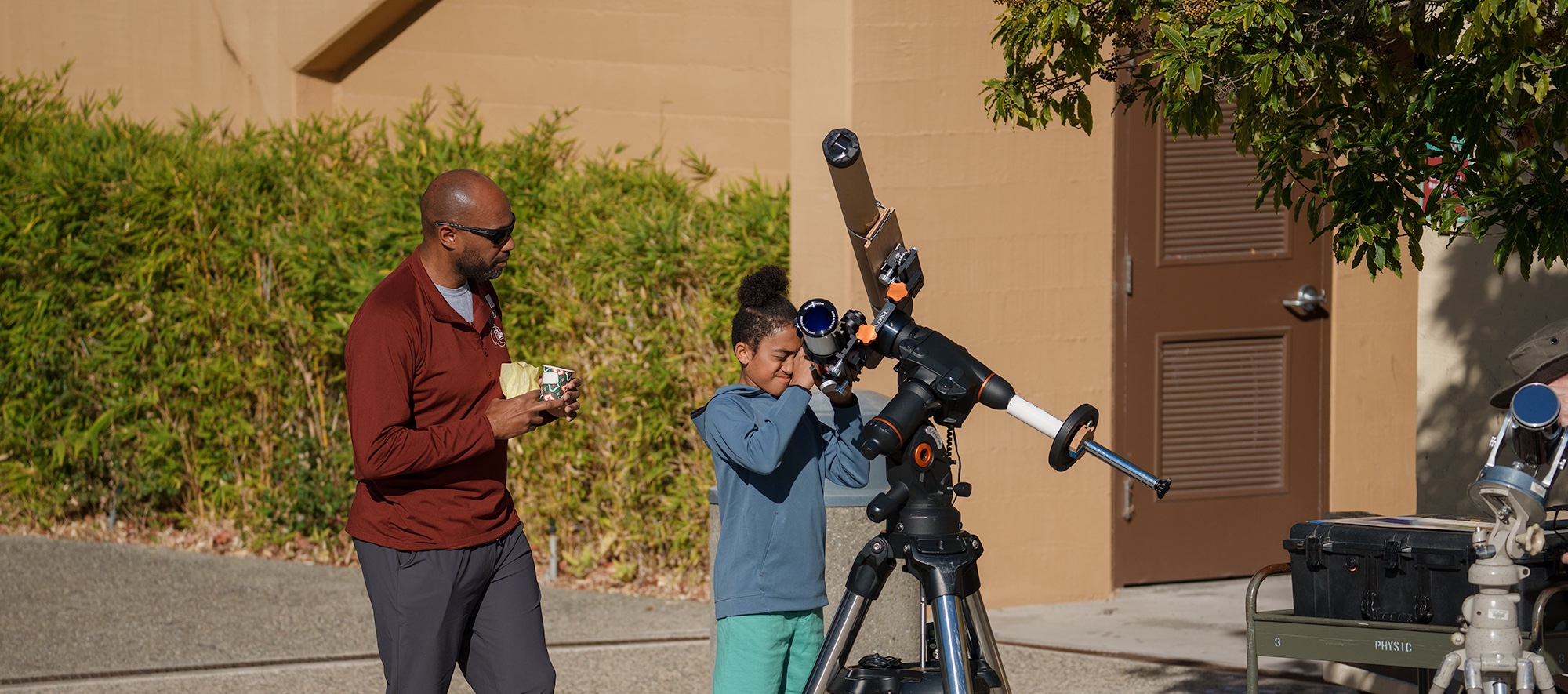 Parent Watching Child Look Through Telescope at MPC Family Stem Day