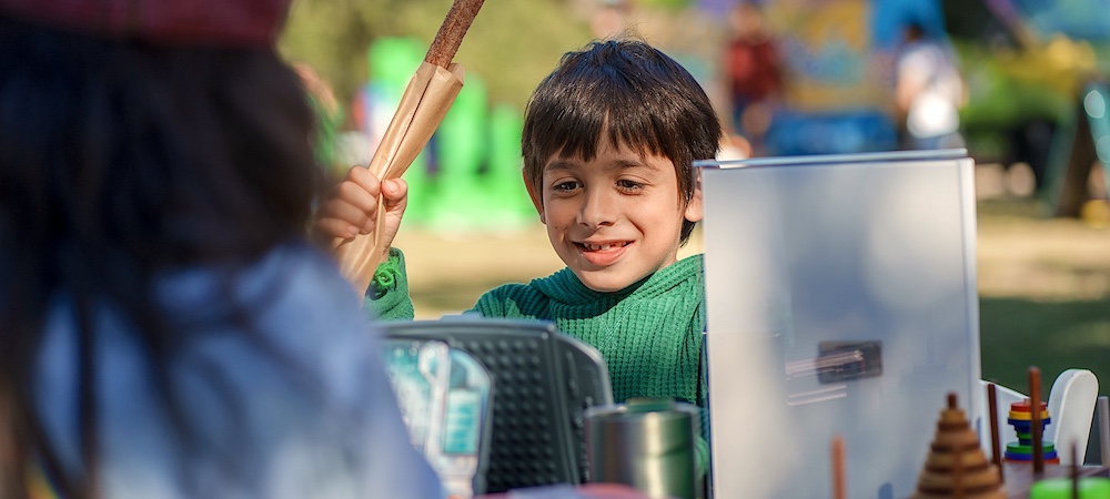 Child Holding Churro and Participating in Family STEM Day