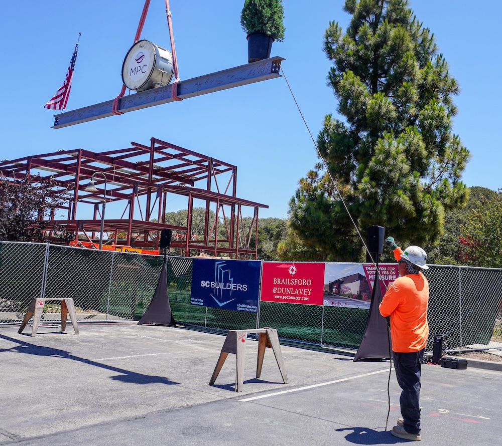 Construction Worker Lifting Beam into Place