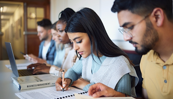 Students Writing Notes and Reading in Class