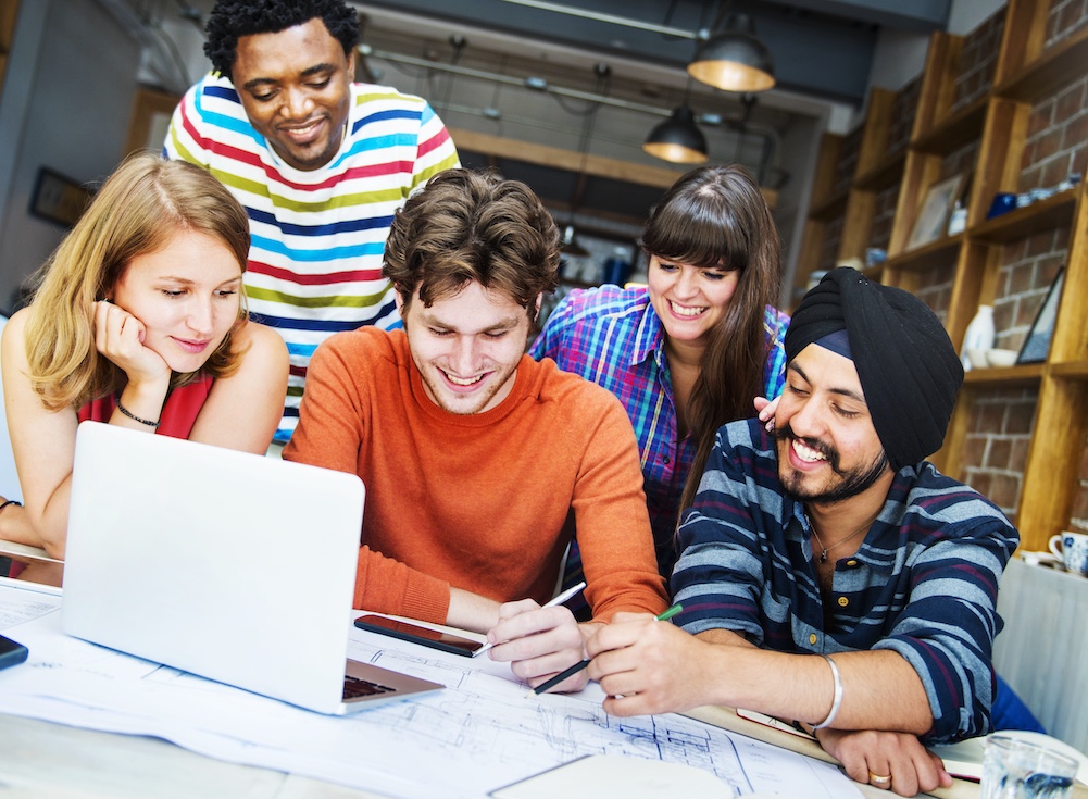 Group of College Students Working on Homework Together in Library