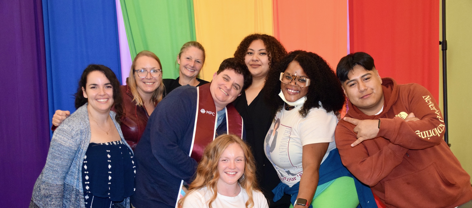 Students Posing In Front of LGBTQIA Flag