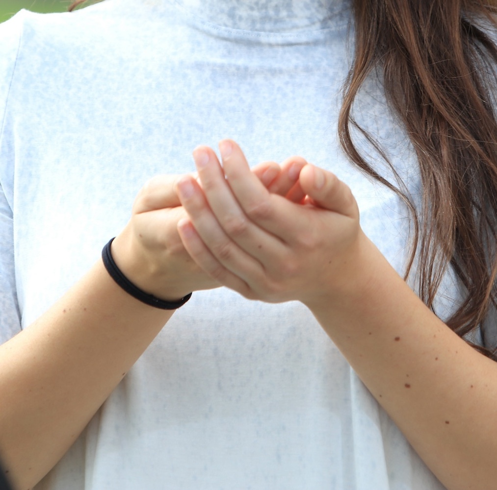 Student holding hands together